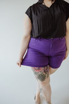 Don't let the name fool you, and these shorts are anything but plain! The TUMMY CONTROL ROLLED CUFF SHORTS IN PURPLE RAIN are high-waisted (12") for a flattering fit and feature a cuffed inseam of 5" (7" when uncuffed). Embrace the warmer weather with confidence and comfort. Fits true to Judy Blue sizing. If you have not worn Judy Blue jeans before, go one size down from your typical size. Cara is wearing a size 3x. Want more information about the model? Visit our Lovely Models page. Wash Handwa Purple Bottoms With Built-in Shorts And Short Inseam, Purple Bottoms With Built-in Shorts, Purple Stretch Athletic Shorts, Purple Fitted High-waisted Shorts, Fitted Purple Shorts Mid-thigh Length, Fitted Purple Shorts, Mid-thigh Length, Fitted Purple Mid-thigh Length Shorts, Purple Relaxed Fit Shorts, Judy Blue Jeans