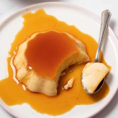 a white plate topped with pancakes covered in caramel sauce next to a bowl of syrup