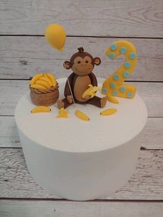 a birthday cake with a monkey on top and bananas in the bottom, next to it's number one