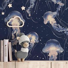 a teddy bear sitting on top of a wooden shelf in front of jellyfish wallpaper