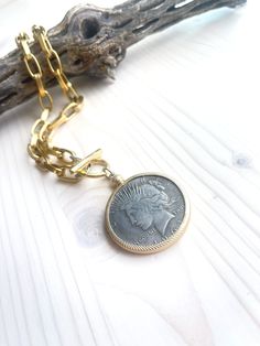 The same beautiful coin medallion as seen in the Gloria Necklace but with a heavier brass chunky chain. Necklace closes with hammered gold over brass toggle clasp. Chain measures 18.5 inches in length, pendant adds additional 2.5 inches. Wear this with anything. Coin details may vary slightly. All jewelry items are delivered to you wrapped perfect for gift giving! Gold-tone Medallion Necklace With Coin Pendant, Nickel-free Yellow Gold Medallion Coin Necklace, Vintage Gold-tone Chain Necklace With Coin Pendant, Brass Chain Necklace With Coin Pendant, Vintage Gold-tone Coin Necklace, Vintage Medallion Coin Necklace With Large Pendant, Gold-tone Metal Medallion Necklace With Coin Pendant, Brass Medallion Chain Necklace With Coin Pendant, Nickel Free Brass Medallion Necklace With Round Pendant