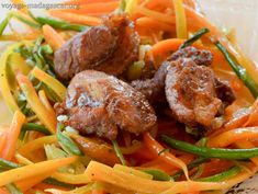 meatballs and carrots are mixed together in a salad with green beans on the side