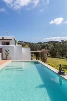 Outdoor pool in front of villa, surrounded by lush lawn and trees Luxury Vacation