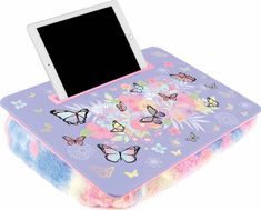 an electronic device is sitting on top of a colorful blanket with butterflies and flowers all over it