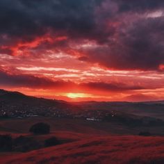 the sun is setting over a valley with hills in the background