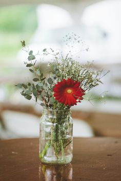 a vase filled with flowers on top of a wooden table