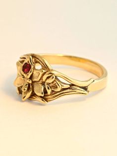 This detailed Orchid Ring is cast in solid 14K gold. A 2.5mm ruby is set in the center of the flower and the leaves of the orchid flow around the finger to form the band. It is 1/3 of an inch wide and rests flat against the finger. We will contact you to let you know if we have your chosen ring size in stock or when to expect shipment. All Marty Magic Jewelry is packaged in a beautiful ring box embossed with the gold foil Marty Magic dragon logo. Perfect for any occasion! Designed in Santa Cruz, 14k Gold Flower Shaped Gemstone Rings, Heirloom 14k Gold Flower Ring With Gemstone, Heirloom 14k Gold Hallmarked Flower Ring, 14k Gold Hallmarked Flower Promise Ring, Flower-shaped Yellow Gold Ruby Ring For Wedding, Flower Shaped Ruby Ring In Yellow Gold For Wedding, Yellow Gold Flower Ruby Ring For Wedding, Yellow Gold Ruby Ring For Wedding With Flower Shape, Yellow Gold Birthstone Flower Ring