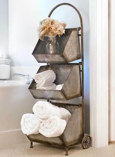 a metal rack with towels and other items on it in the corner of a bathroom