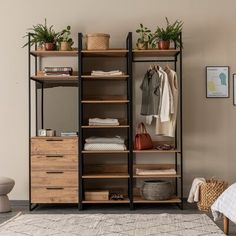 an open closet with clothes and plants on shelves