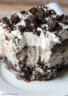 a close up of a piece of cake on a plate with oreo cookies and cream