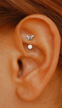 a woman's ear is shown with three small diamond studs on the side