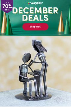 a metal robot sitting on top of a desk next to a green sign that says wayfair december specials