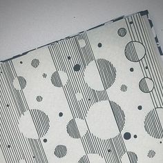 a piece of paper with black and white designs on it, sitting on top of a table