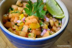 a blue bowl filled with pineapple salsa and garnished with cilantro