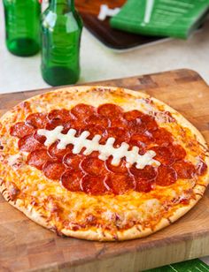 a pepperoni football pizza on a cutting board