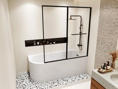 a white bath tub sitting inside of a bathroom next to a sink and counter top