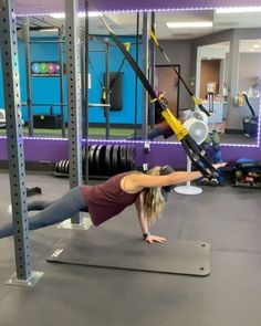 a woman doing push ups in a gym