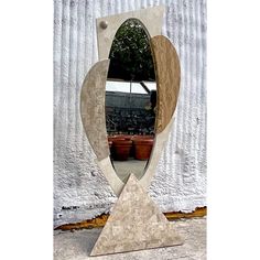 a large mirror sitting on top of a wooden stand in front of a white wall