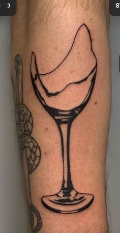 a man's leg with a tattoo on it and a glass of ice cream