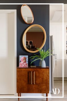 a living room with a mirror on the wall and a wooden cabinet in front of it