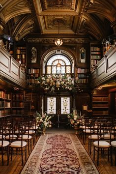 the aisle is lined with chairs and flowers in front of bookshelves, which are decorated with floral arrangements