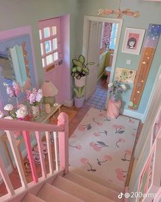 a doll house with pink and blue walls, stairs and flowers in vases on the floor