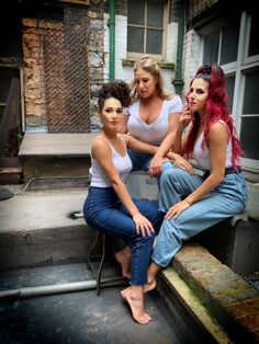 three women are sitting on the steps outside