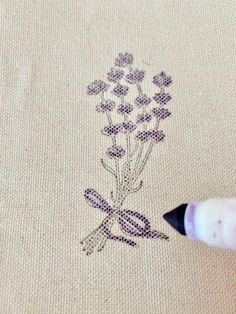 someone is drawing flowers on a piece of fabric