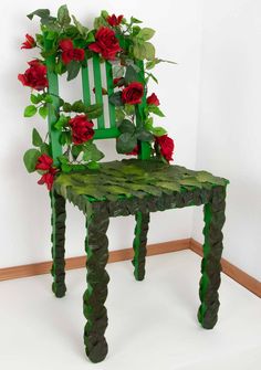 a green chair with red flowers on the back and seat is made out of cardboard