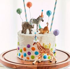 a birthday cake decorated with animals and balloons