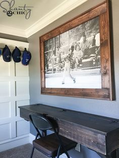 a black and white photo hanging on the wall next to a wooden table with two chairs