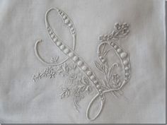 an embroidered piece of cloth with flowers and vines on it