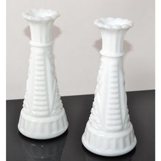 two white vases sitting next to each other on a table