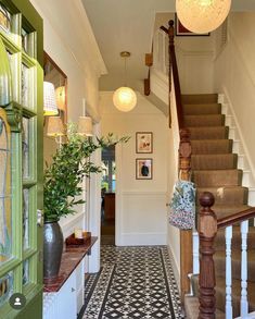 an entry way with stairs and potted plants