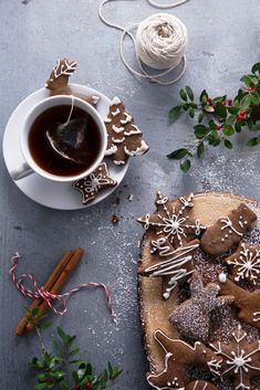 a cup of tea and some cookies on a table next to twine spools