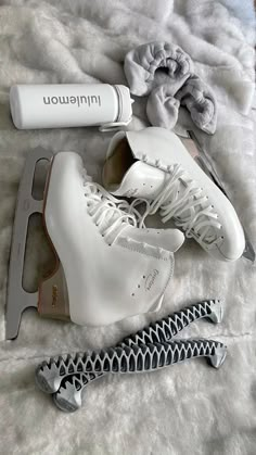 some white shoes are laying on a bed with hairdryer and combs next to them