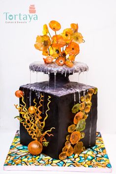 there is a cake decorated with flowers and icing on the top of it's stand