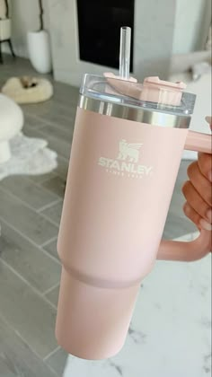 a person holding up a pink tumbler cup