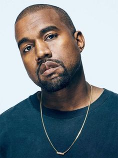 a close up of a person wearing a necklace and looking off to the side with a serious look on his face