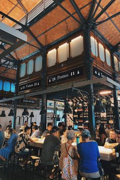 People sitting inside Mercado San Miguel Food In Madrid, Grey Wallpaper Clouds, Madrid Market, Madrid Aesthetic, Borough Market, International Food