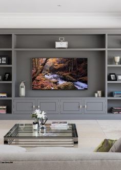 a living room filled with furniture and a flat screen tv mounted to the side of a wall