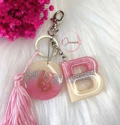 two key chains with pink and white designs on them