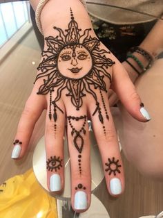 a woman's hand with hennap and sun design on the top of it