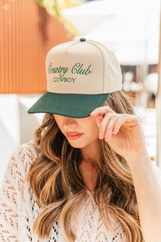 Calling all cowgirls! Elevate your style with our Country Club Cowboy Trucker Hat. Featuring an embroidered western graphic, this trendy hat is the perfect accessory to complete any casual outfit. Perfect for spring and summer, wear it to concerts and festivals for a chic and fashionable look. Available in 2 colors! Twill cap Made in USA Embroidery at front and side panel Adjustable back strap Brim measures approx 3" in lengthOS measures approx 23.55" in circumference Retro Cotton Trucker Hat For Summer, Retro Summer Cotton Trucker Hat, Casual Curved Brim Snapback Hat For Country Events, Casual Summer Hats For Country Concerts, Country Style Snapback Hat For Rodeo With Flat Brim, Western Flat Brim Baseball Cap For Rodeo, Retro Summer Hats For Country Events, Country Style Flat Brim Snapback Hat For Rodeo, Country Style Baseball Cap