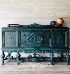 an old dresser is painted green and has ornate carvings on it