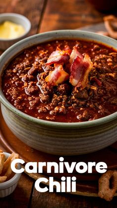 a bowl of chili with bacon on top