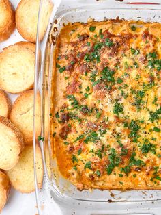 a casserole dish with cheese and bread on the side