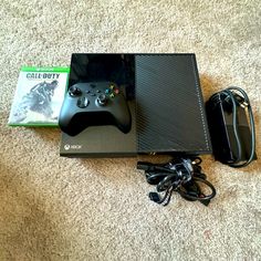 a video game console sitting on top of a carpeted floor next to a controller