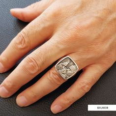 a man's hand with a silver ring on it