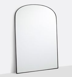 an arched mirror is shown against a white wall